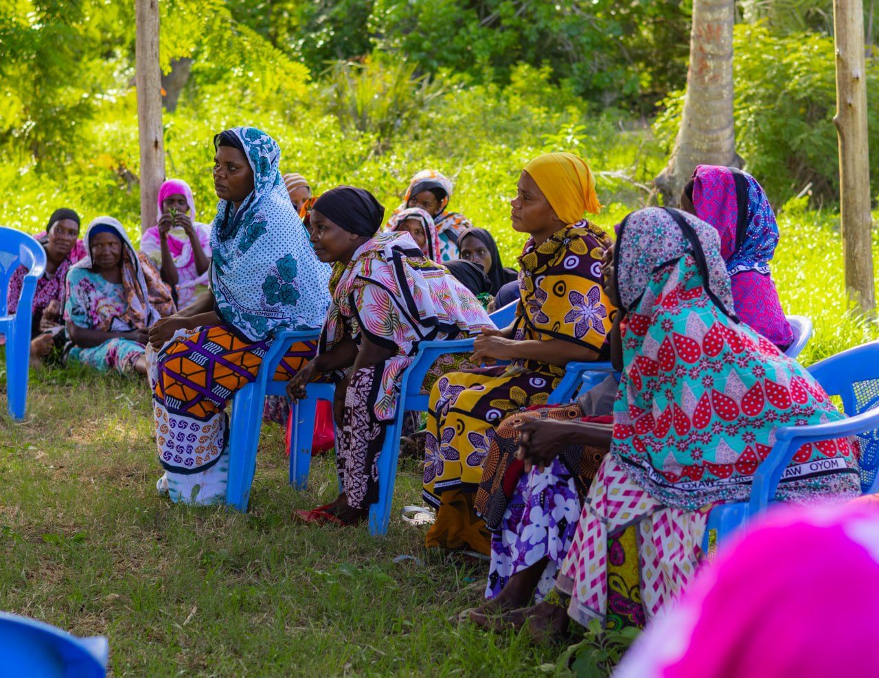 Community members seated at an open-air project design meeting in Kwale